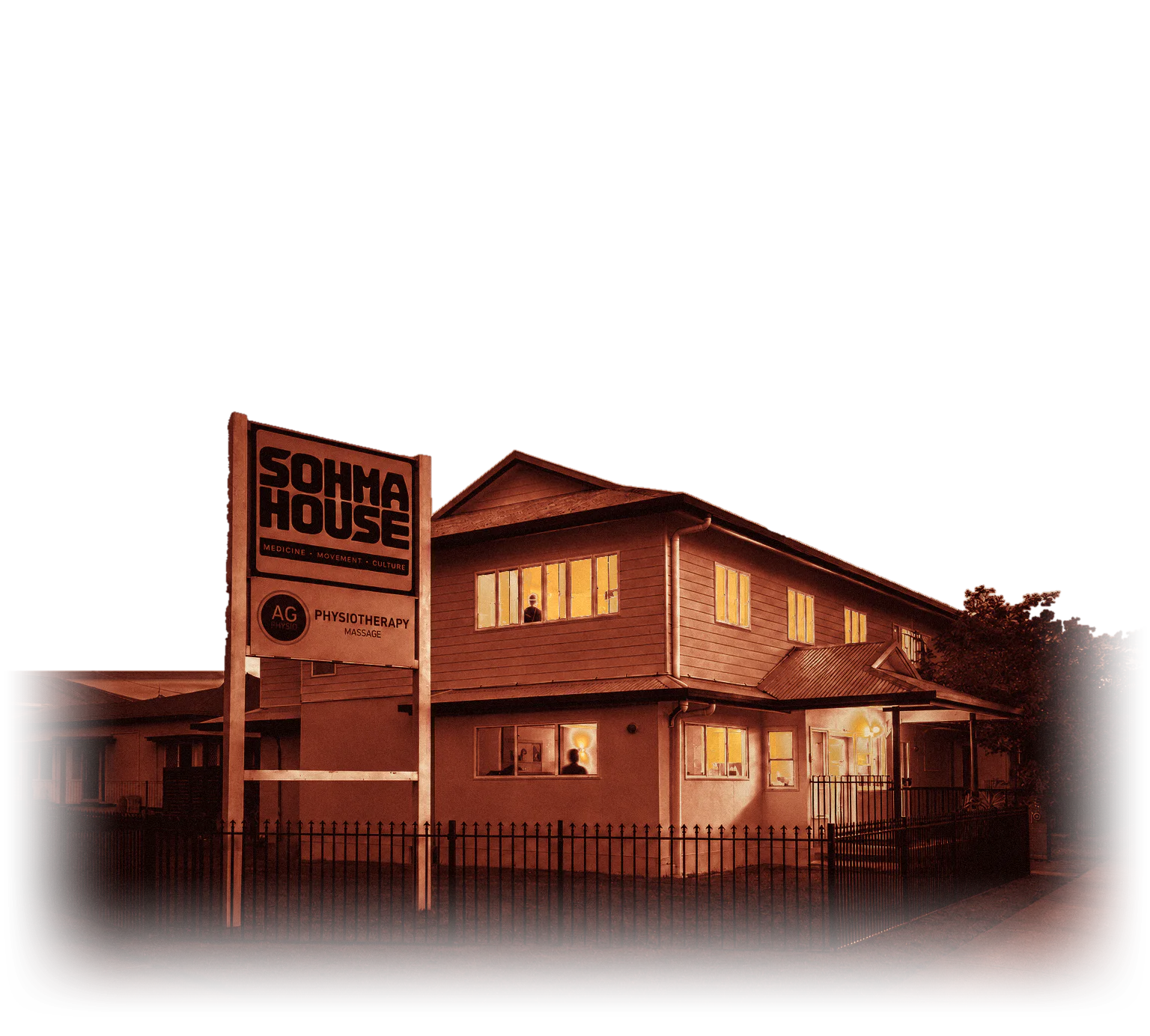 Sohma House at dusk, its windows lit, with the Om in a burst of light above the roof.